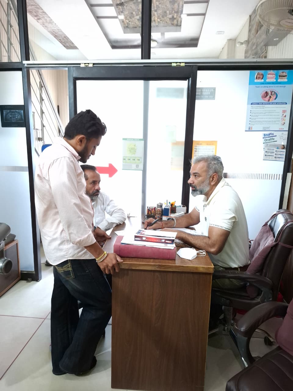 Dentist consulting with patients at the reception desk