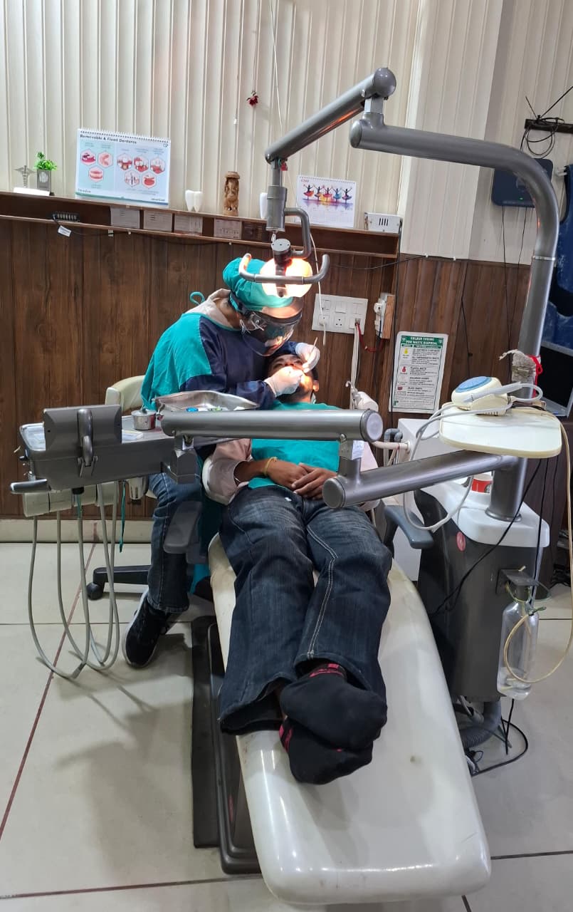 Dentist performing a dental procedure in surgical attire