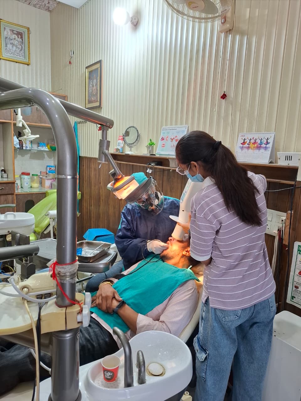 Dentist at Bhandari Dental Clinic treating a patient with assistant support
